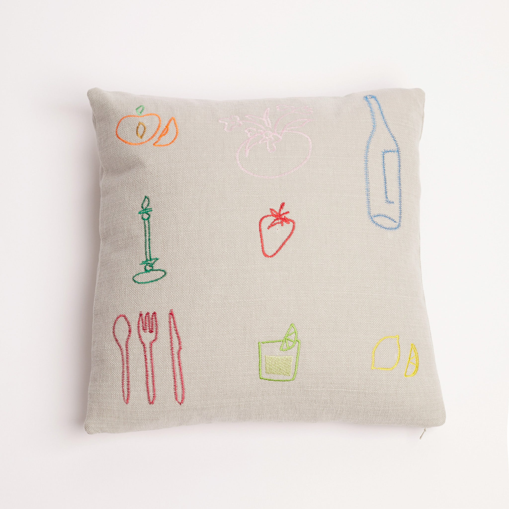 Neutral linen cushion with colourful embroidered food and drink icons on a white background. Neutral linen cushion with colourful embroidered food and drink icons on a white background.