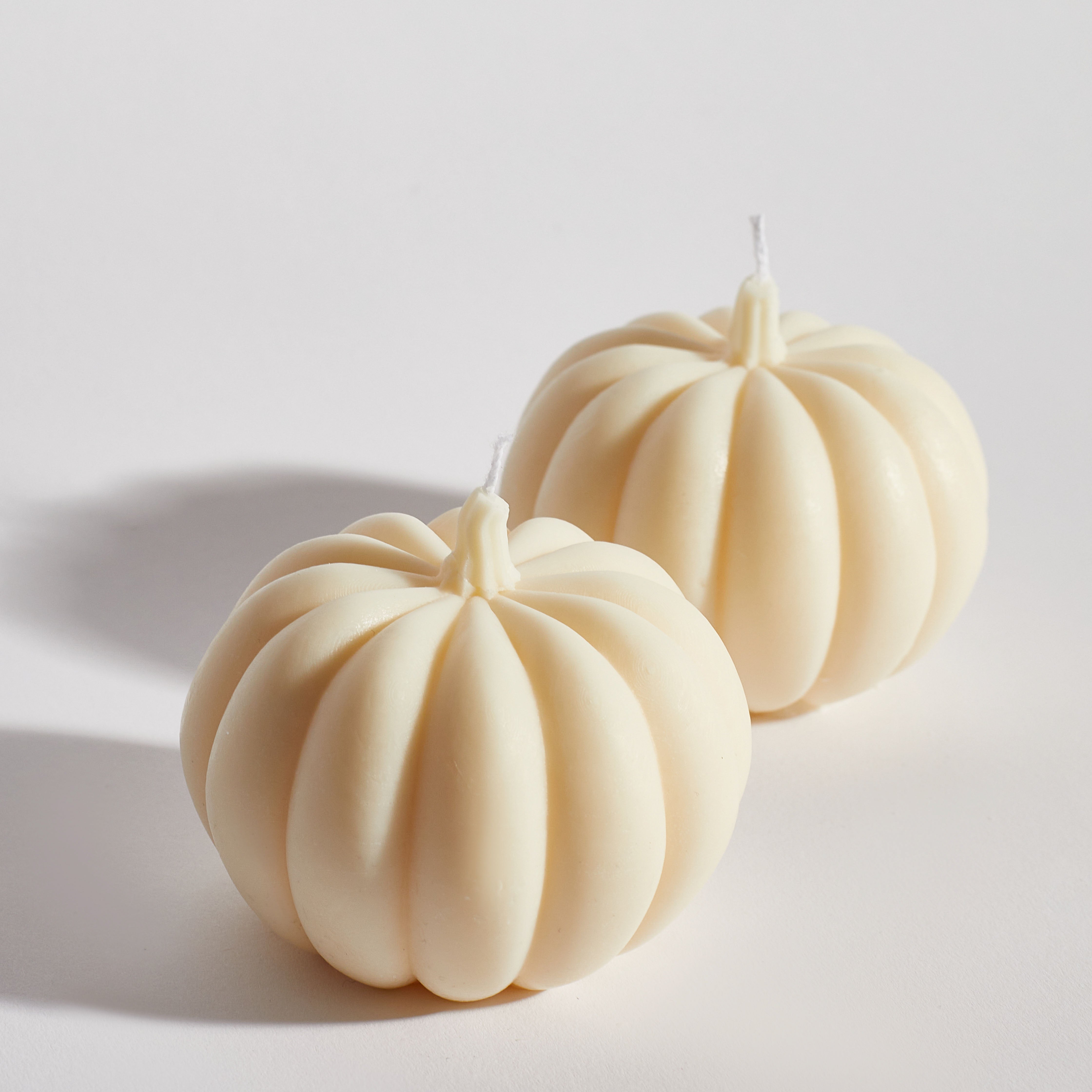 Two Boujie Medium Pumpkin Decorative Candles side by side close up, handmade in soy wax with classic cream finish. Two Boujie Medium Pumpkin Decorative Candles side by side close up, handmade in soy wax with classic cream finish.