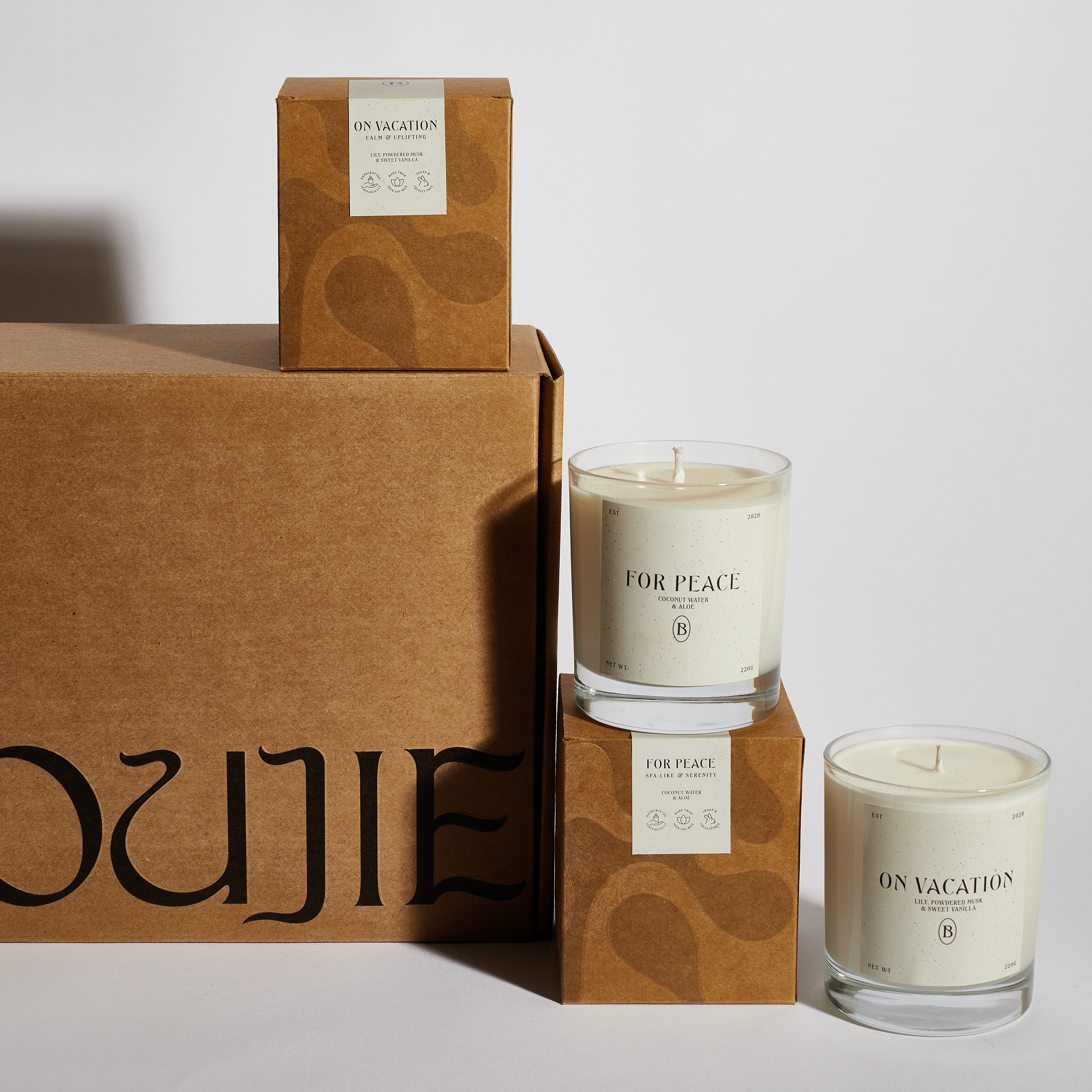 Boujie On Vacation and For Peace scented soy jar candles displayed with eco-friendly packaging. Boujie On Vacation and For Peace scented soy jar candles displayed with eco-friendly packaging.