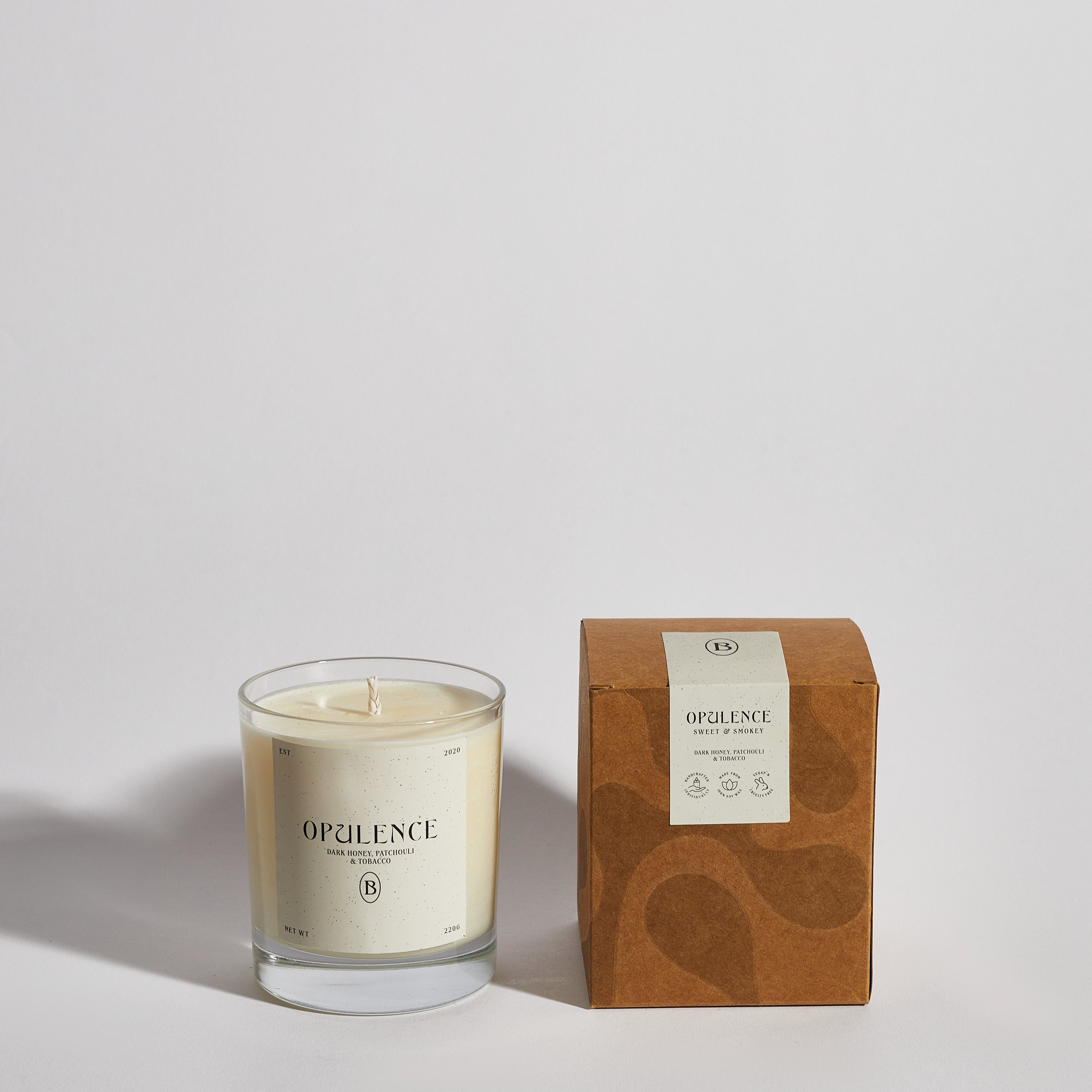 Boujie Opulence luxury soy wax jar candle, front view with packaging, handmade with natural soy wax in a clear glass jar, scented with dark honey, patchouli, and tobacco. Boujie Opulence luxury soy wax jar candle, front view with packaging, handmade with natural soy wax in a clear glass jar, scented with dark honey, patchouli, and tobacco.