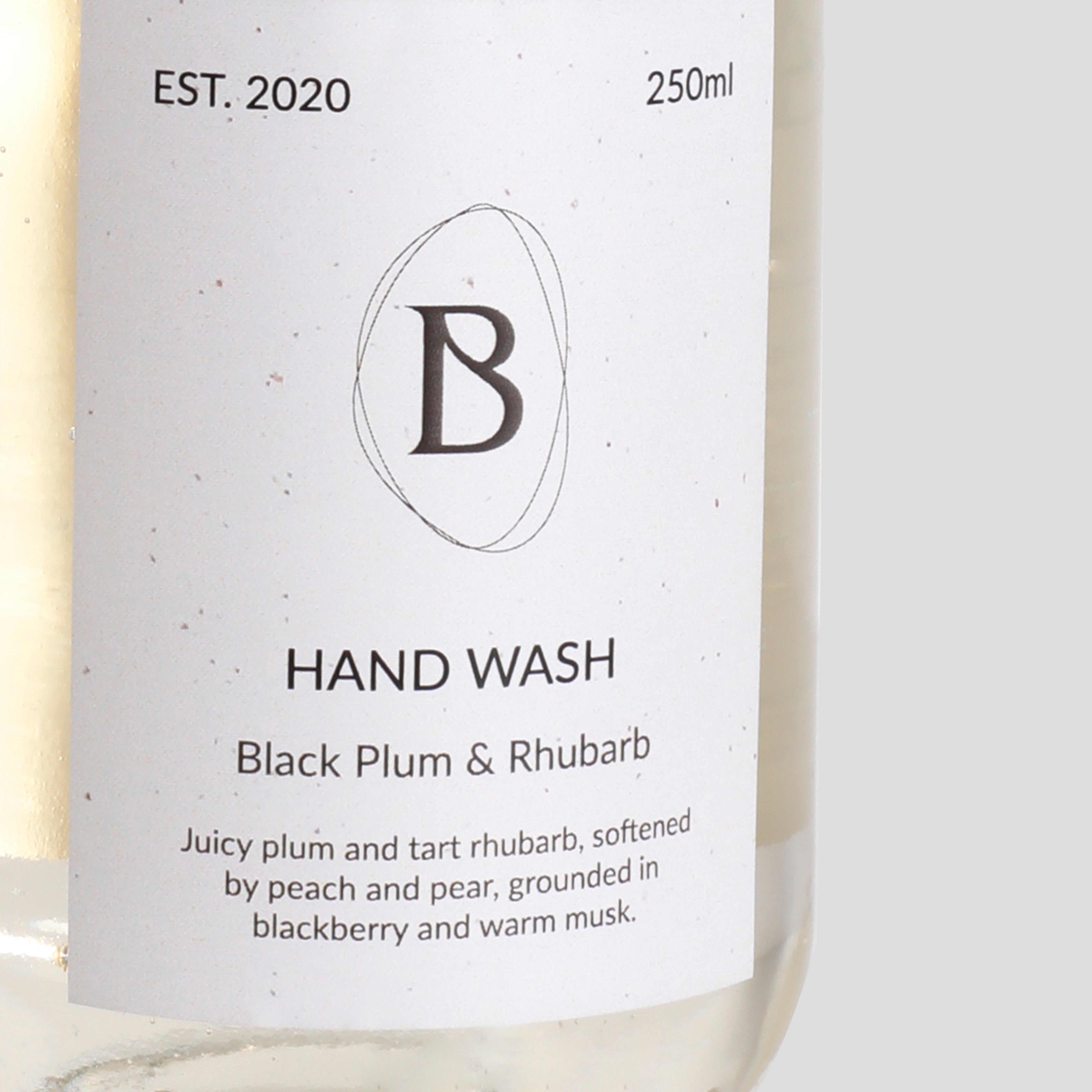 Hand wash bottle with label featuring 'Black Plum & Rhubarb' fragrance on a white background