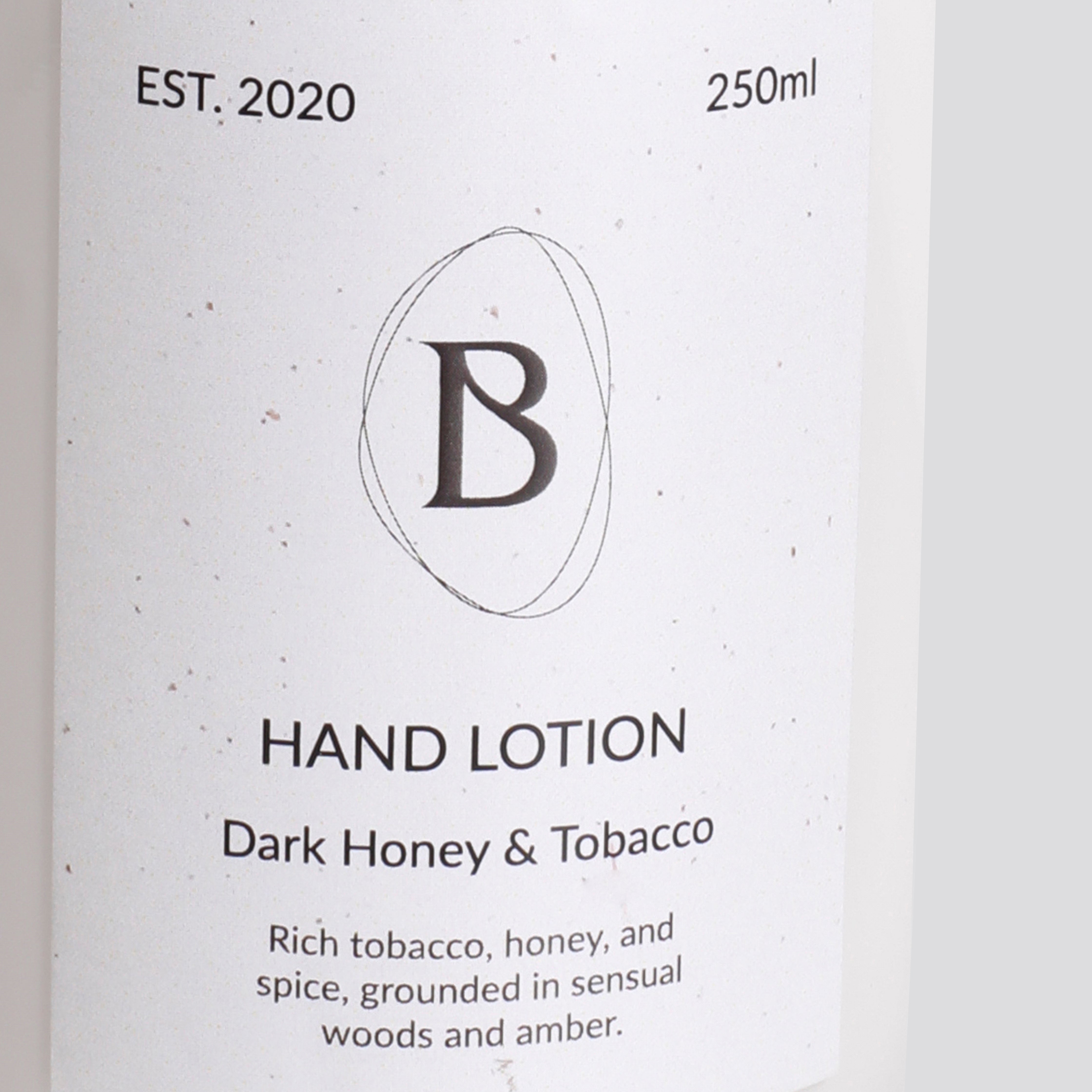 Hand lotion packaging with brand logo and product description on a light background