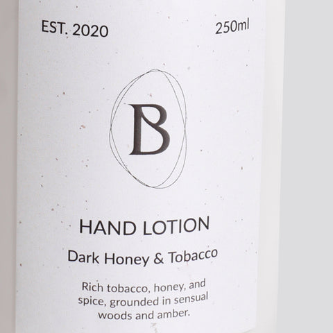 Hand lotion packaging with brand logo and product description on a light background