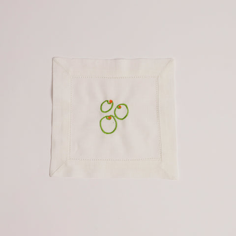 Single white cocktail napkin embroidered with three green olives and red pimento detail.