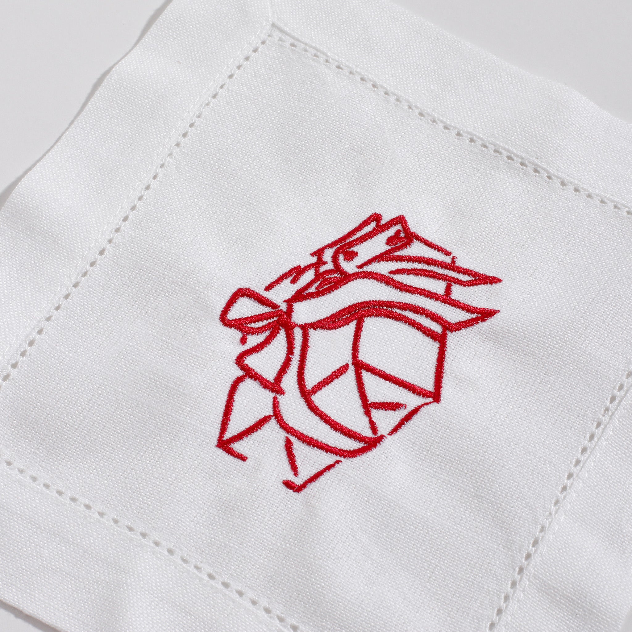Red embroidered design on a white fabric background