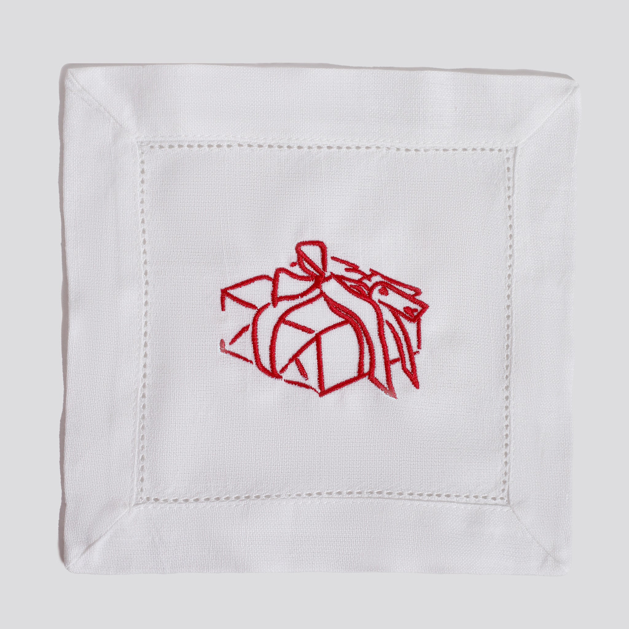 White fabric square with red embroidered gift box design on a white background