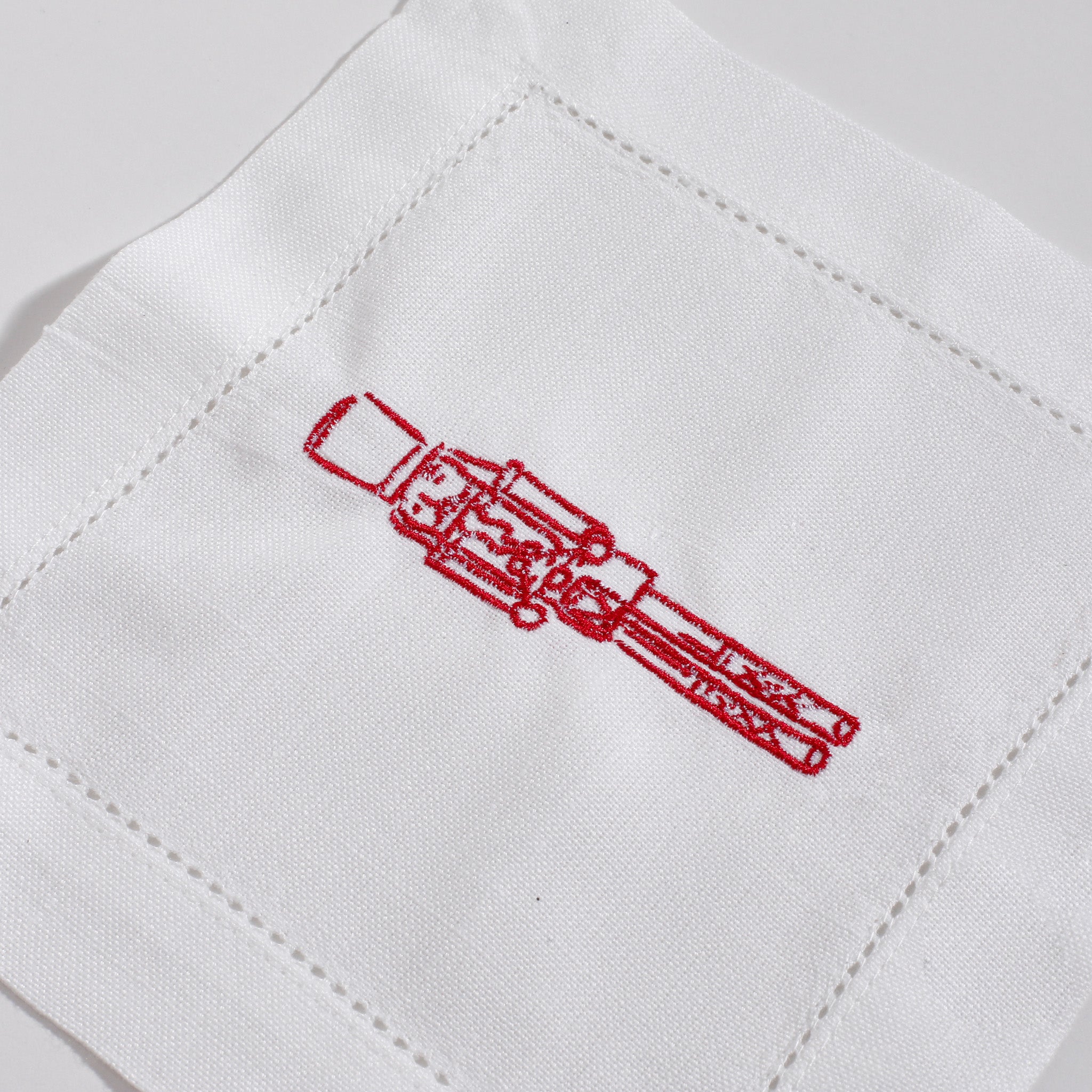 Red embroidery of a rifle on a white fabric background