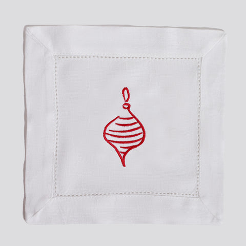 White napkin with a red embroidered Christmas ornament on a white background