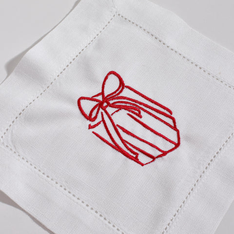 White fabric with red embroidered bow design on a white background
