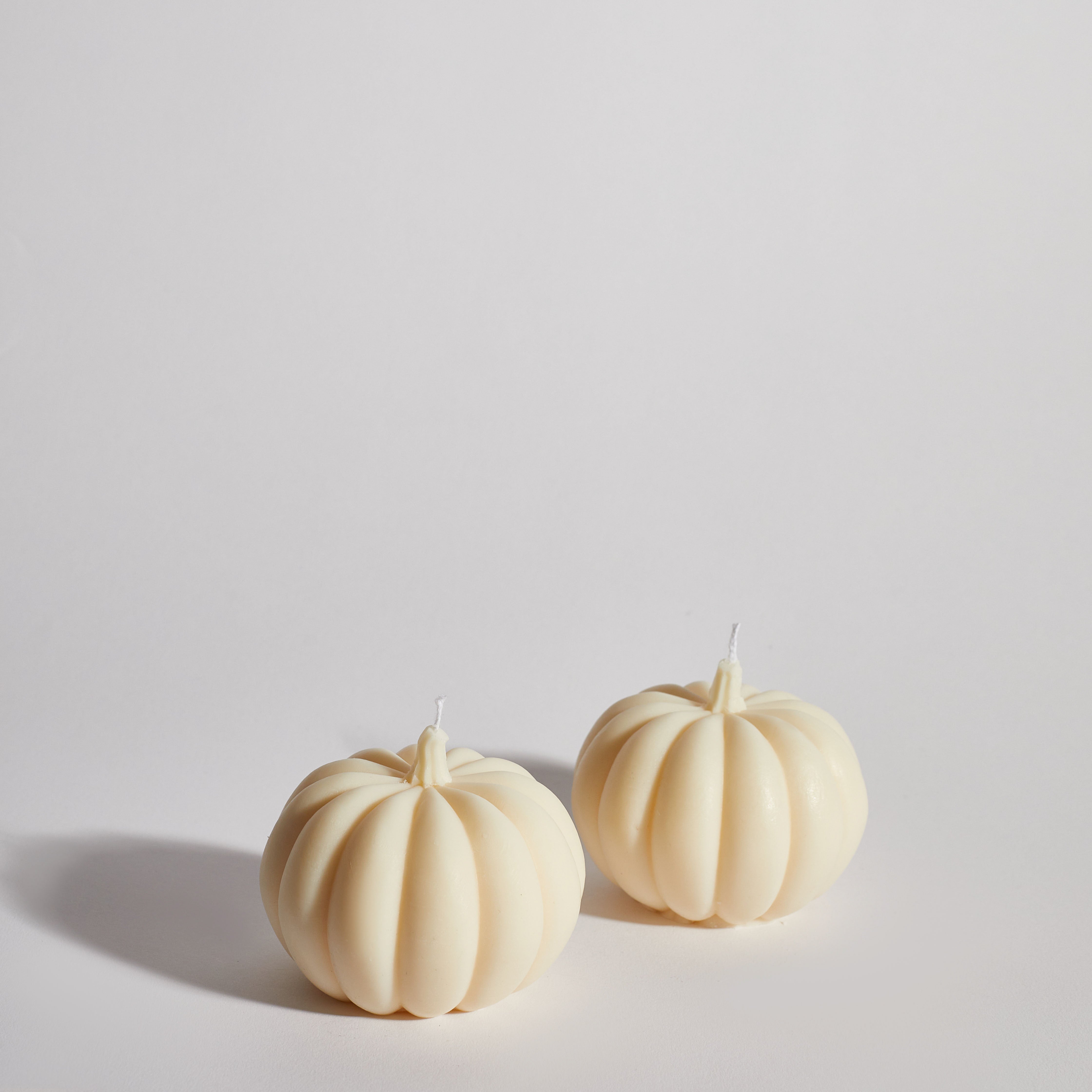 Two Boujie Medium Pumpkin Decorative Candles side by side, handmade in soy wax with classic cream finish.