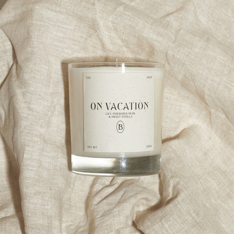 Boujie On Vacation luxury soy wax jar candle, front view, handmade with natural soy wax in clear glass jar, scented with lily, powdered musk, and sweet vanilla.