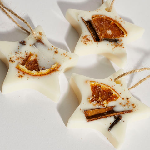 Close-up of natural soy wax star ornament with festive botanicals.