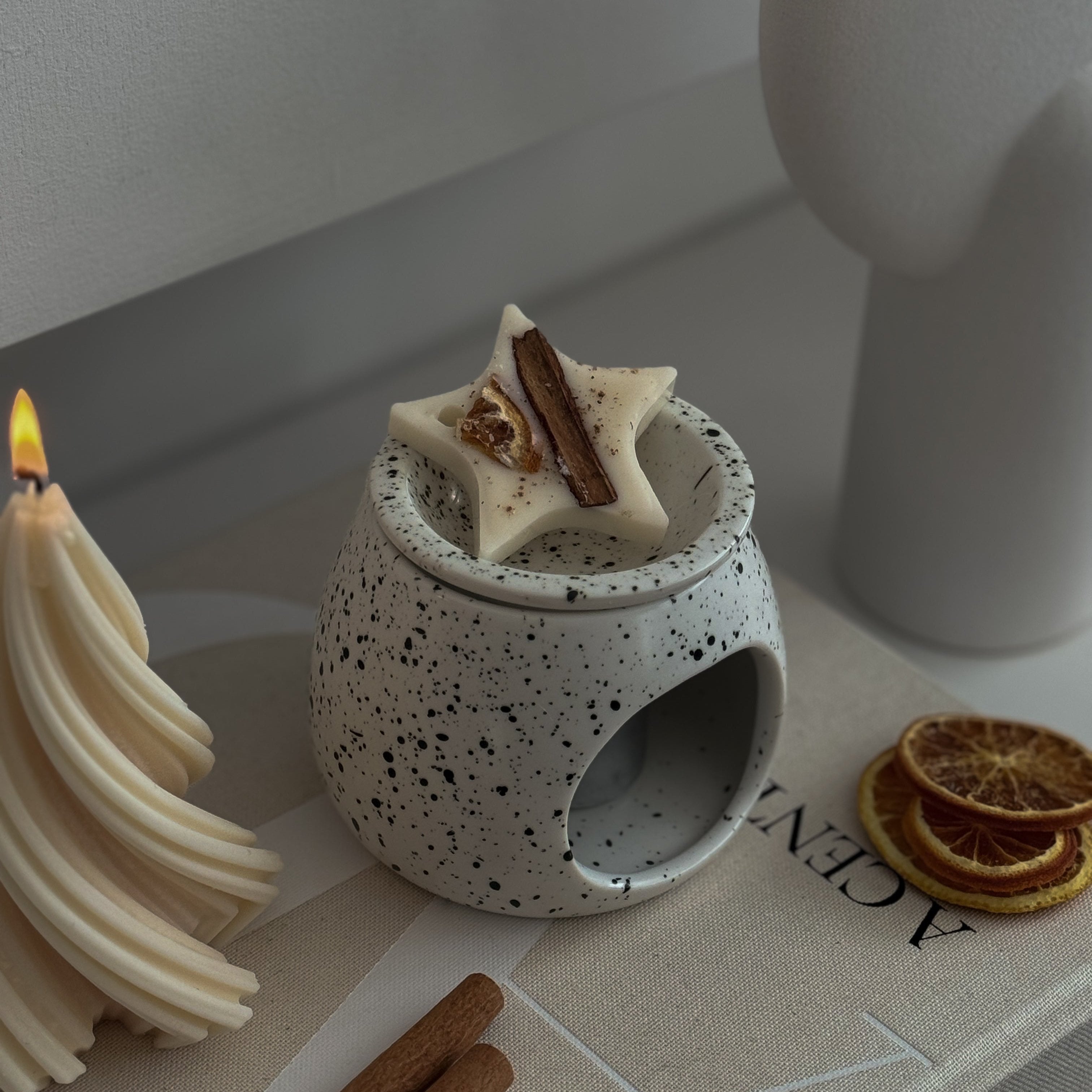 Star-shaped soy wax melt decoration on a ceramic burner, festive display.